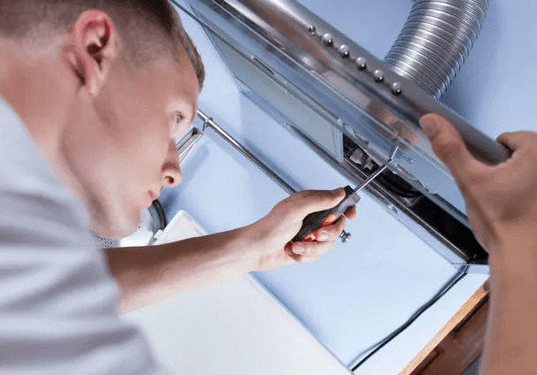 A man working on an exhaust fan.